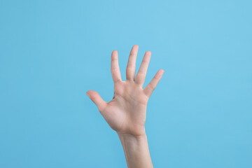 Woman giving high five on light blue background, closeup