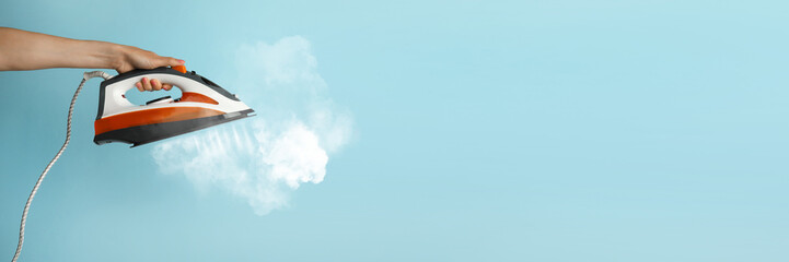 Woman with iron on light blue background, closeup. Banner design with space for text