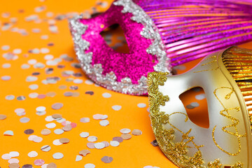 two colored masks on an orange background with ornaments