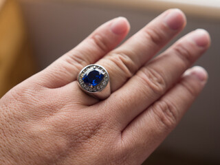 Blue stone silver ring on finger, close up
