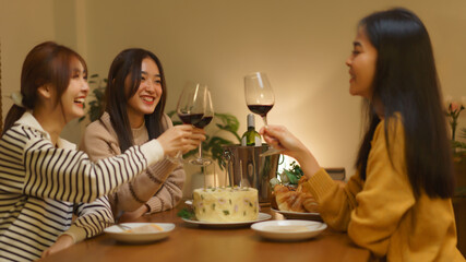 Birthday celebration concept, Asian girls clinking glass wine in dinner to celebrate birthday party