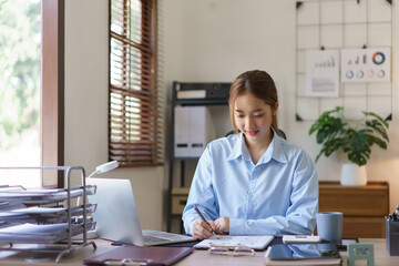 Startup business concept, Businesswomen reading finance data and writing in document at workplace