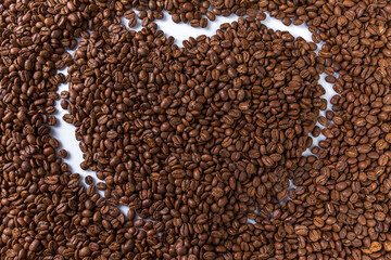 Coffee grains in the shape of a heart. Appetizing morning drink. Background. Space for text.