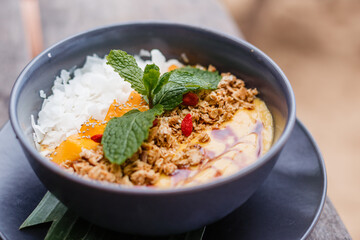 Fruity delicious smoothie bowl with mint on a plate. Fresh fruit salad for a healthy lifestyle. Proper nutrition and fresh delicious food for health