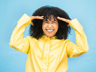 Face, thinking and laugh with a black woman on a blue background in studio for fun or laughter....
