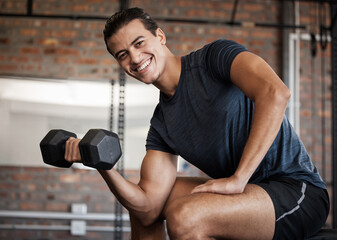 Portrait, fitness and dumbbell with a sports man training in a gym for strong or healthy muscles....