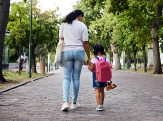Mother, child and walking with backpack holding hands to school for safety at the outdoor park. Mom...