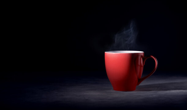 Hot Red Coffee Cup on Table with Stream. Dark Tone, Side View with more Copy Space