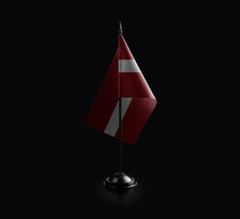 Small national flag of the Latvia on a black background