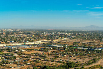 The city of Tuscon with houses and homes on the outskirts of downtown with open pastures and yards near residences