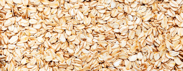 Raw organic oatmeal, food background texture, top view horizontal banner