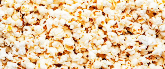 Salted popcorn background or texture, close-up, top view banner