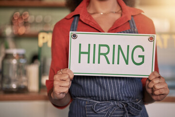 Small business, hands or business owner with a hiring sign for job vacancy offer at a cafe or coffee shop. Recruitment, marketing or female entrepreneur standing with an onborading message in store