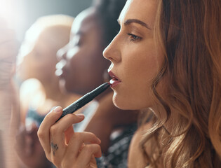 Makeup, lipstick and woman in bathroom of nightclub, gen z friends getting ready for party or music concert. Cosmetics, diversity and women backstage at theater, fashion show or dark night club.