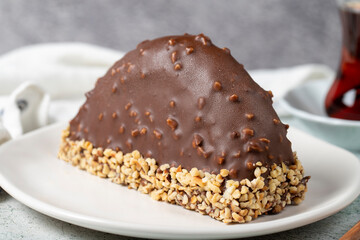 Chocolate Banana Cake. Malaga cake with banana inside, chocolate and hazelnut outside on a stone background. close up