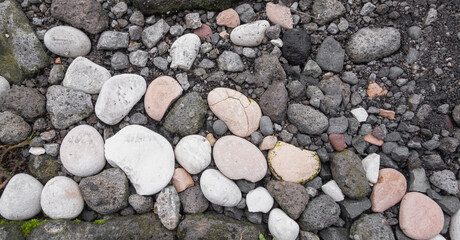 full frame of white and gray stones in dirt pavement background and wallpaper texture