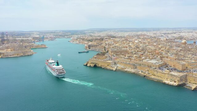 Cruise liner ship in ocean floats out of the historic bay. Aerial top view