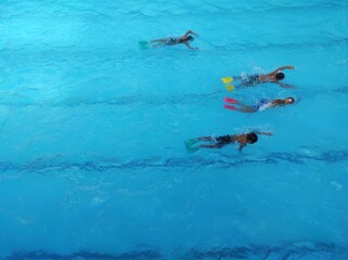 High angle view of Children practice swimming in the pool