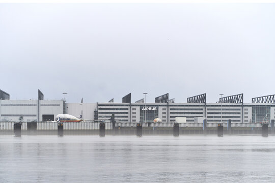 24.12.2022 Hamburg, Germany. Airbus factory on the river. Exterior view of the Airbus factory in Hamburg-Finkenwerder. Big aircraft parts are in front of the building.