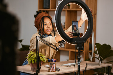 Obraz na płótnie Canvas Communication, phone and influencer live streaming podcast, radio talk show or speaker talk about teen culture. Presenter microphone, black woman setup broadcast or speaking about online student news