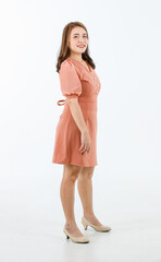 Portrait studio shot Asian polite happy female fashionable professional successful businesswoman in formal working peach color dress outfit standing posing smiling look at camera on white background