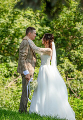 The bride and groom in a wedding dress in nature.