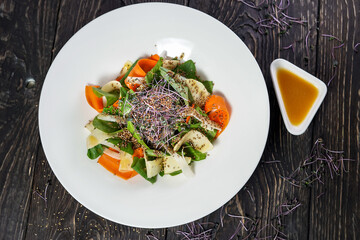 salad with spinach, pear and quinoa in a plate on a dark background
