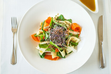 salad with spinach, pear and quinoa in a plate on a white background
