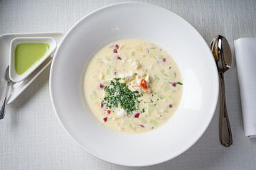 cold okroshka soup in a white plate on a white background
