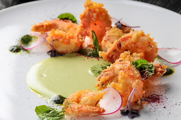 fried shrimp in batter in a plate with greens and radish macro
