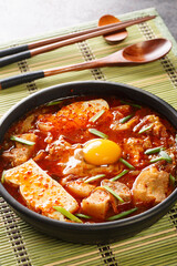 Sundubu Jjigae Spicy Kimchi Soft Tofu Stew closeup on the bowl on the table. Vertical