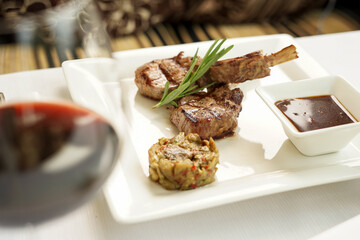 grilled meat square in a square plate with sauce
