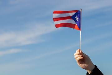 puerto rican flag in hand flutters in the wind against the sky, independence national day of puerto...
