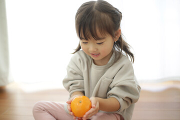 みかんを持つ女の子