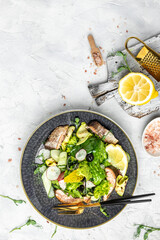 salad with smoked red fish with fresh vegetables, lettuce leaves on a white background, Restaurant menu, dieting, cookbook recipe top view