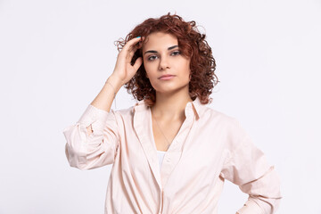 Portrait of a girl with a serious expression on her face. Short curly hair.