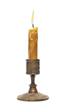 Burning old candle vintage bronze candlestick isolated on a transparent background