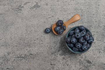 Raw Organic Blueberries in a Bowl on a gray background,