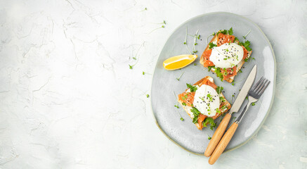 healthy breakfast with poached eggs, salmon and guacamole on toast. Long banner format. top view