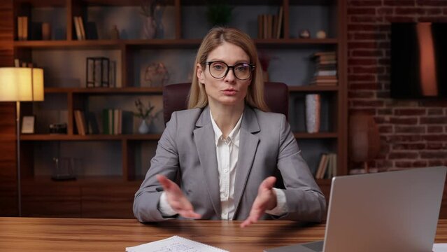 Serious concentrated businesswoman looking at camera make conference business call, recording video blog, talking with client, distance job interview, e-coaching, online training concept, headshot por