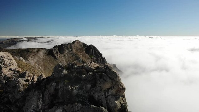 4K drone footage over woman on a rocky peak overlooking mountain range and sea of clouds at La Maroma summit, Malaga, Spain.
Mid angle, traveling movement.