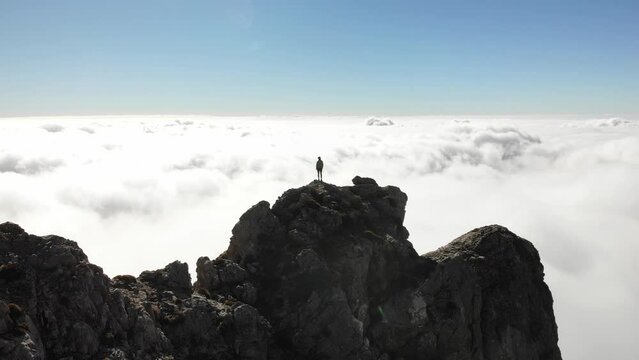 4K drone footage over woman on a rocky peak overlooking breathtaking sea of clouds at La Maroma summit, Malaga, Spain.
Mid angle, parallax movement.