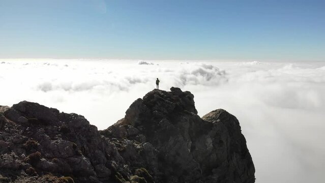 4K drone footage over woman on a rocky peak overlooking breathtaking sea of clouds at La Maroma summit, Malaga, Spain.
Mid angle, parallax movement.