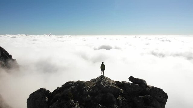4K drone footage over woman on a rocky peak overlooking breathtaking sea of clouds at La Maroma summit, Malaga, Spain.
Mid angle, traveling movement.