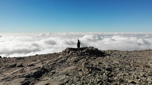 4K drone footage over woman on a rocky peak overlooking breathtaking sea of clouds at La Maroma summit, Malaga, Spain.
Mid angle, parallax movement.