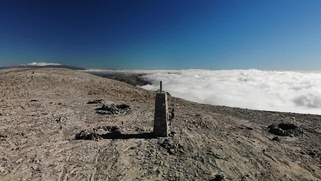 4K drone footage over woman climbing a tower on the summit of a rocky peak overlooking breathtaking sea of clouds and mountain range at La Maroma summit, Malaga, Spain.
Mid angle, parallax movement.