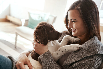 Pet, smile and dog mom in a home on a living room couch with dog bonding with care. Animal love,...
