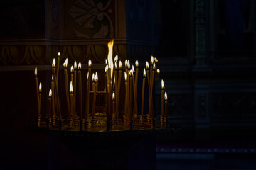 Burning candles in church. Burning candles shining in dark background. Copy space. Shallow depth of field.