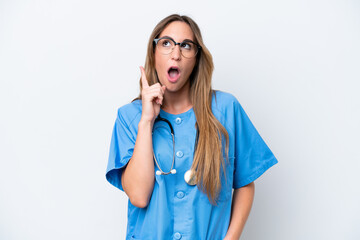 Young surgeon doctor woman isolated on blue background thinking an idea pointing the finger up