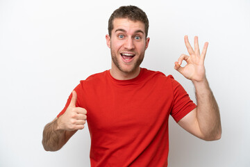 Young caucasian man isolated on white background showing ok sign and thumb up gesture